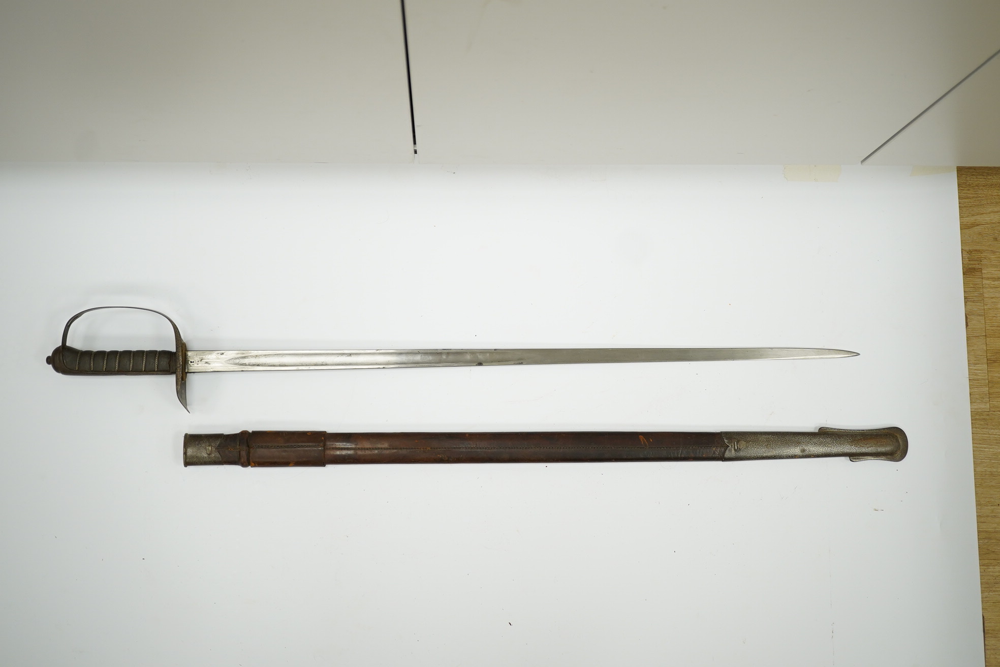 A mid-19th century British infantry sword, by Mole, Birmingham, marked I.S.D., in its leather scabbard with iron chape. Condition - poor, surface rust and knuckle guard significantly cut down.